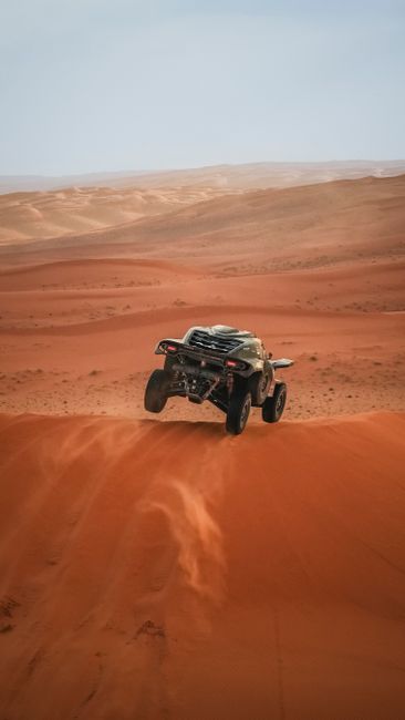 A desert buggy airborne on a sand dune