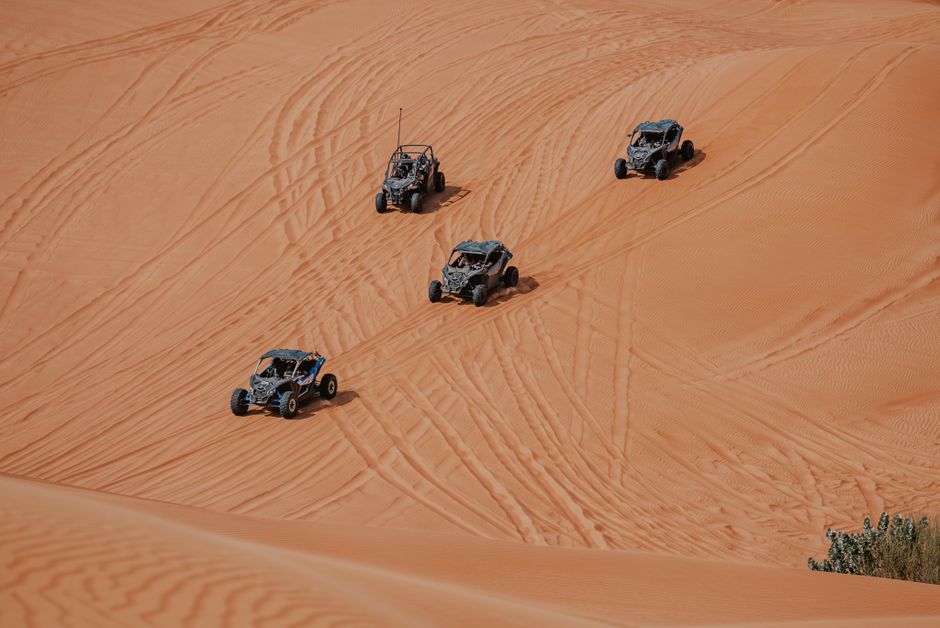 Four buggies driving on sand dunes