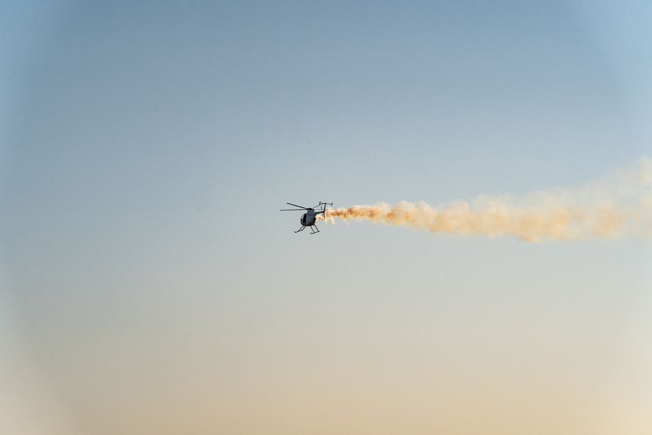 A helicopter firing a gun with smoke trail