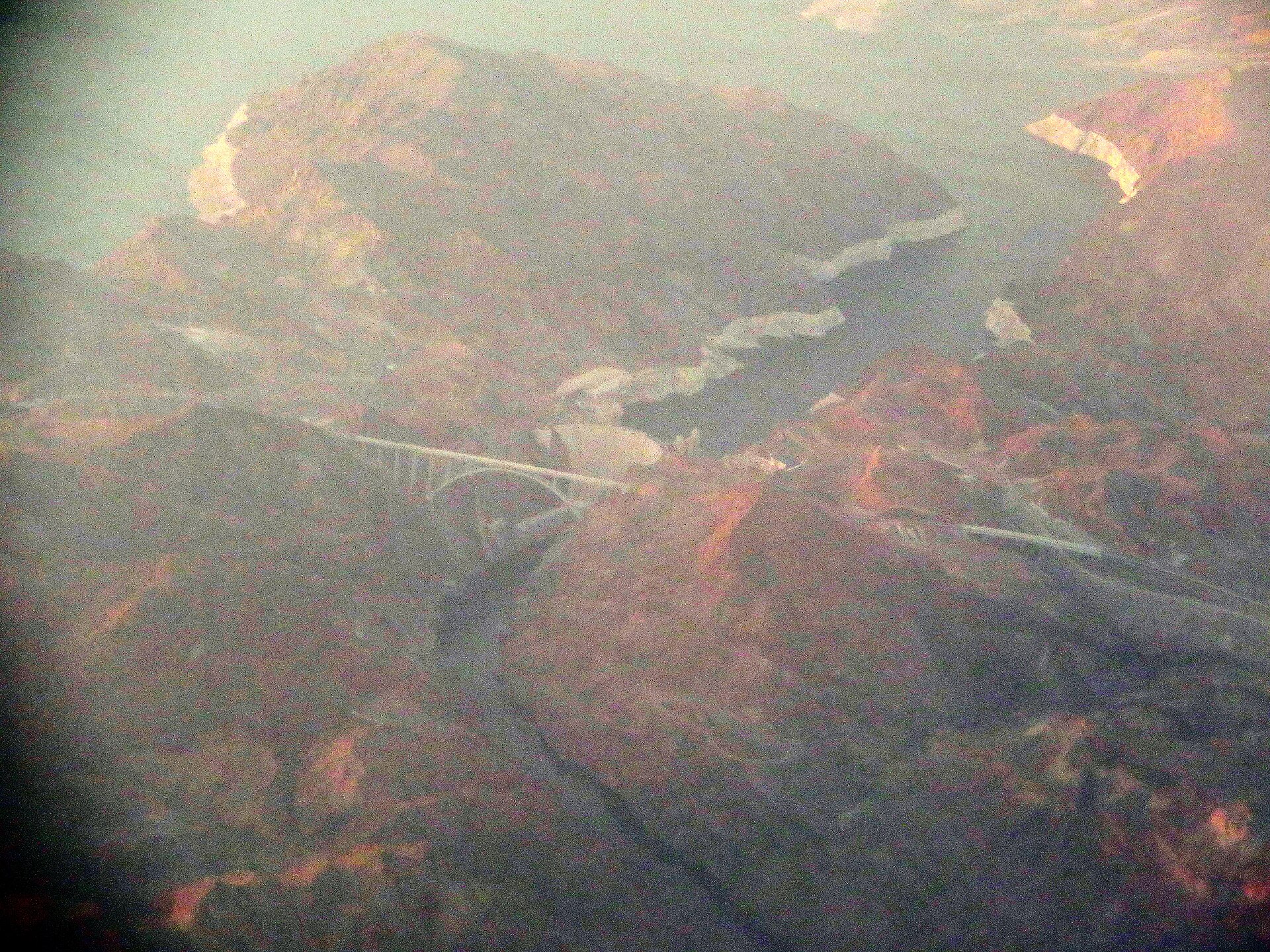 Aerial view of a dam and bridge in a desert landscape
